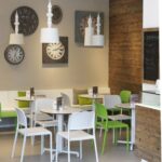 Riva Bistro Chair - Charcoal 5 Riva Chairs in White & Lime with HPL Tables in an Indoor Cafe Setting