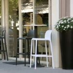 NARDI Faro Tall Bar Stools in White and Charcoal around an outdoor café bar leaner