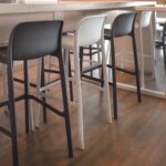 NARDI Faro Tall Bar Stools Charcoal and White at bench in indoor co-working space