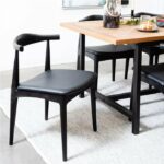 ByDezign Elbow Chair Replica - Black pulled out from table