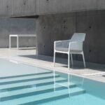 The NARDI Net Relax Lounge Chair in White with Grey Cushions next to pool