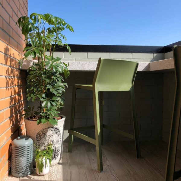NARDI Trill Kitchen Counter Bar Stool in Olive Green on outdoor balcony with pot plant