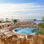 NARDI Atlantico 3-Piece Sun Lounger Sets in White and Taupe around Hotel Pool